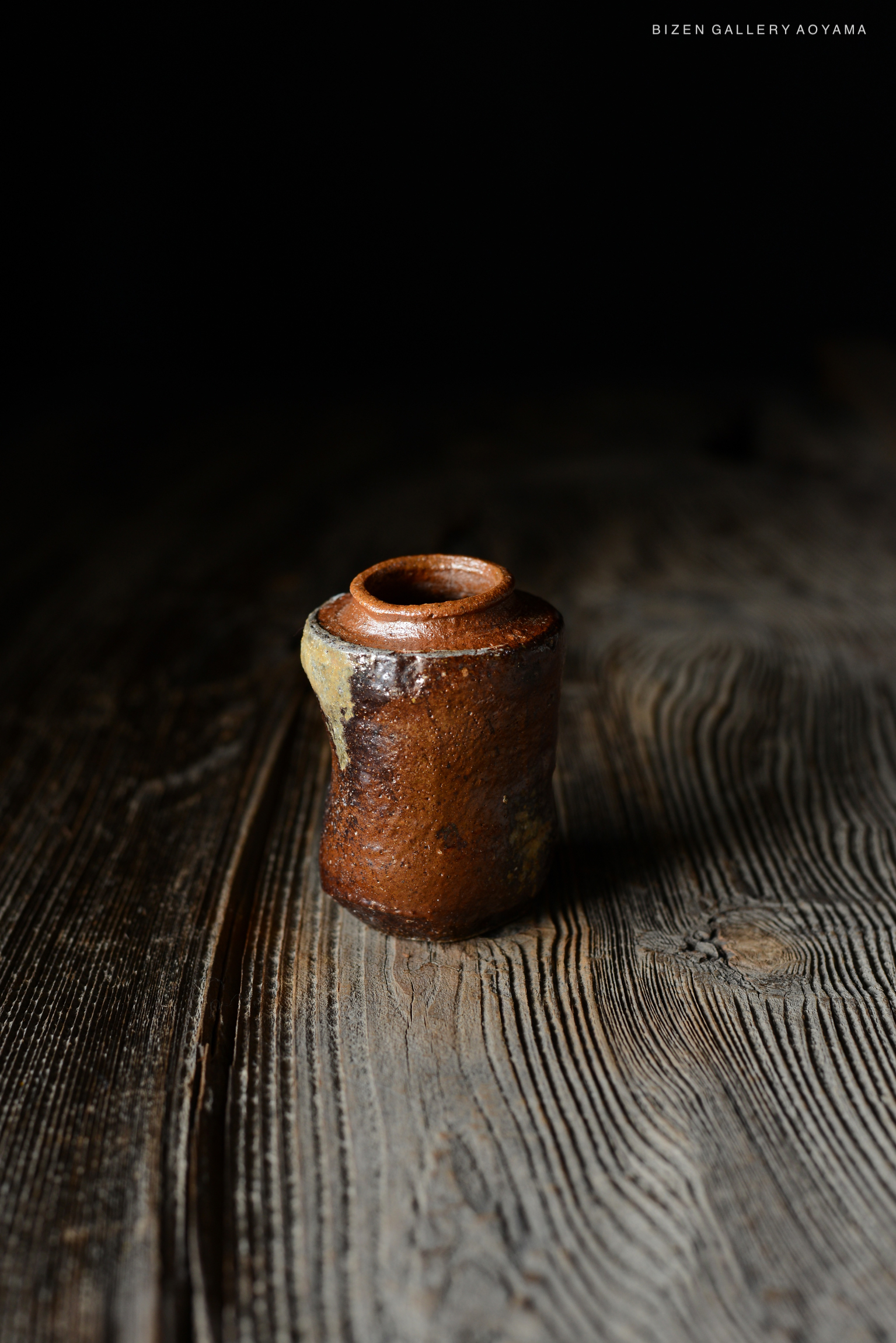 暗い背景に置かれた備前焼の小さな壷
