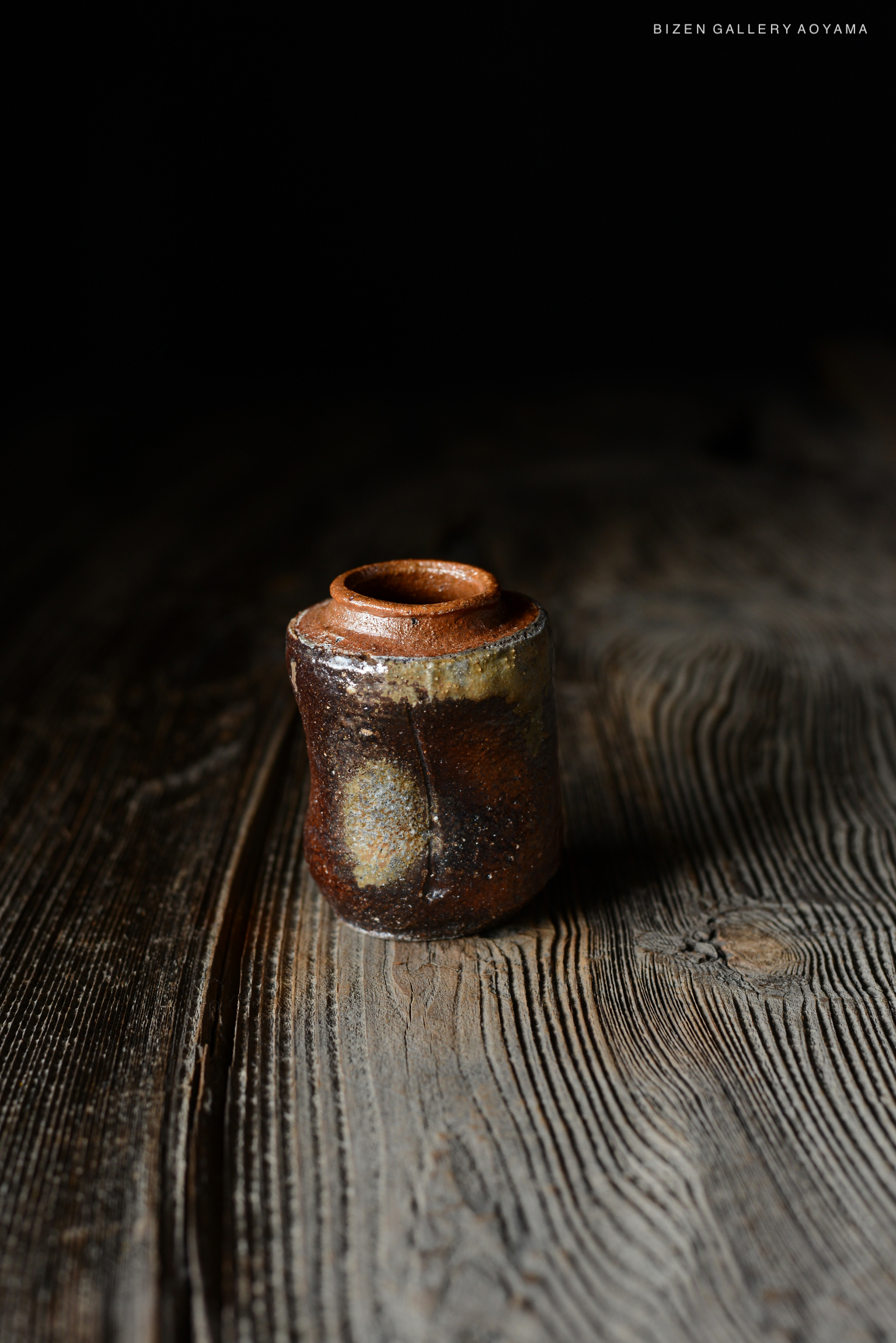木のテーブルの上に置かれたビゼン焼きの小さな壷