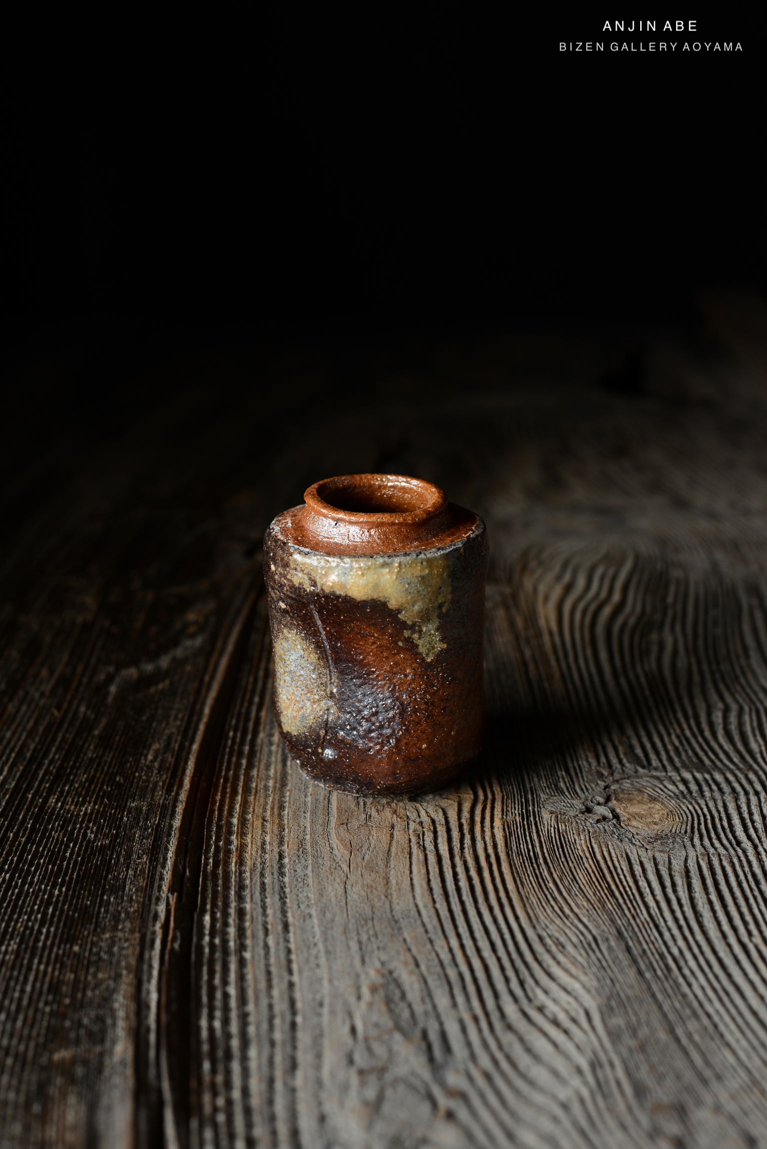 暗い背景の上に置かれた、釉薬のある独特な形の陶器