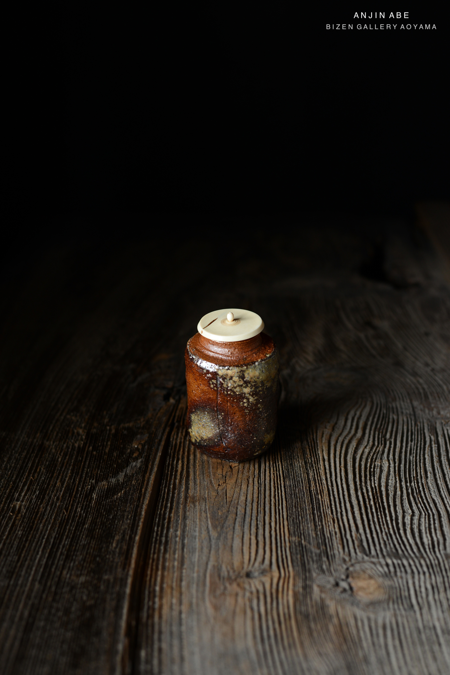 木のテーブルの上に置かれた独特な形の陶器の瓶。