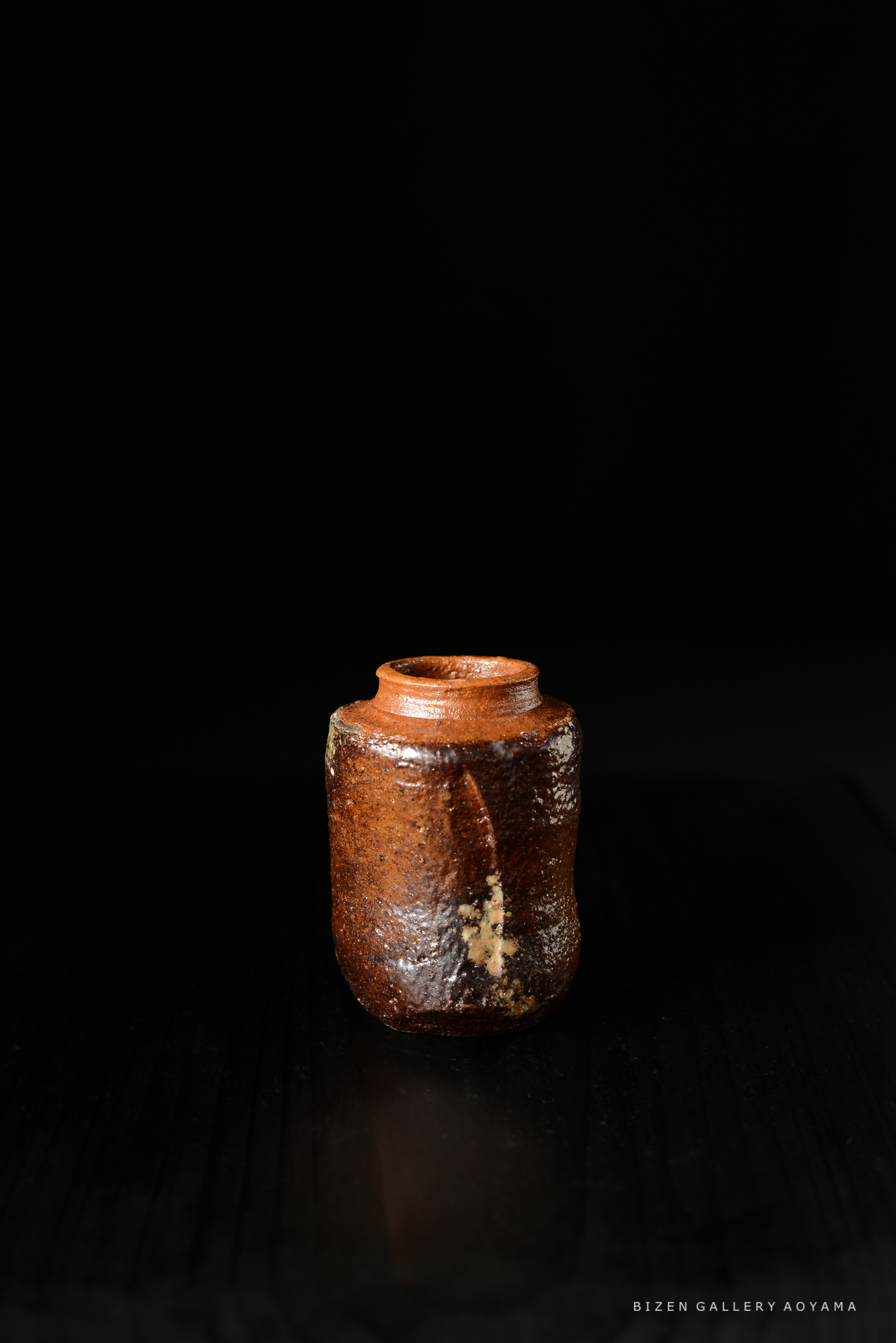 黒い背景に置かれた陶器の壺。