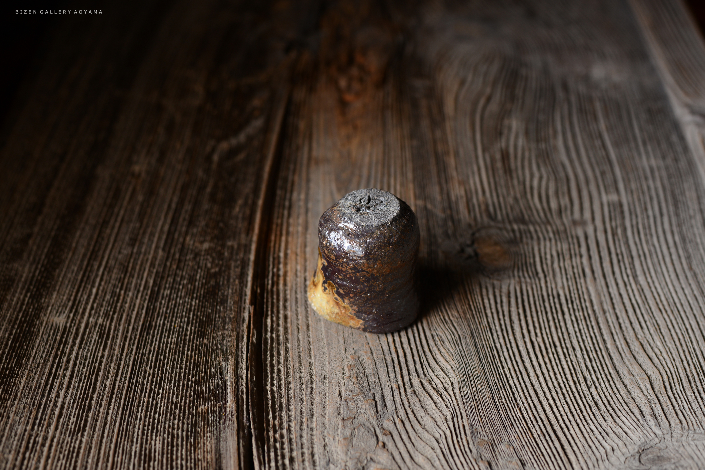 木のテーブルの上に置かれた古い陶器のような形状のオブジェクト