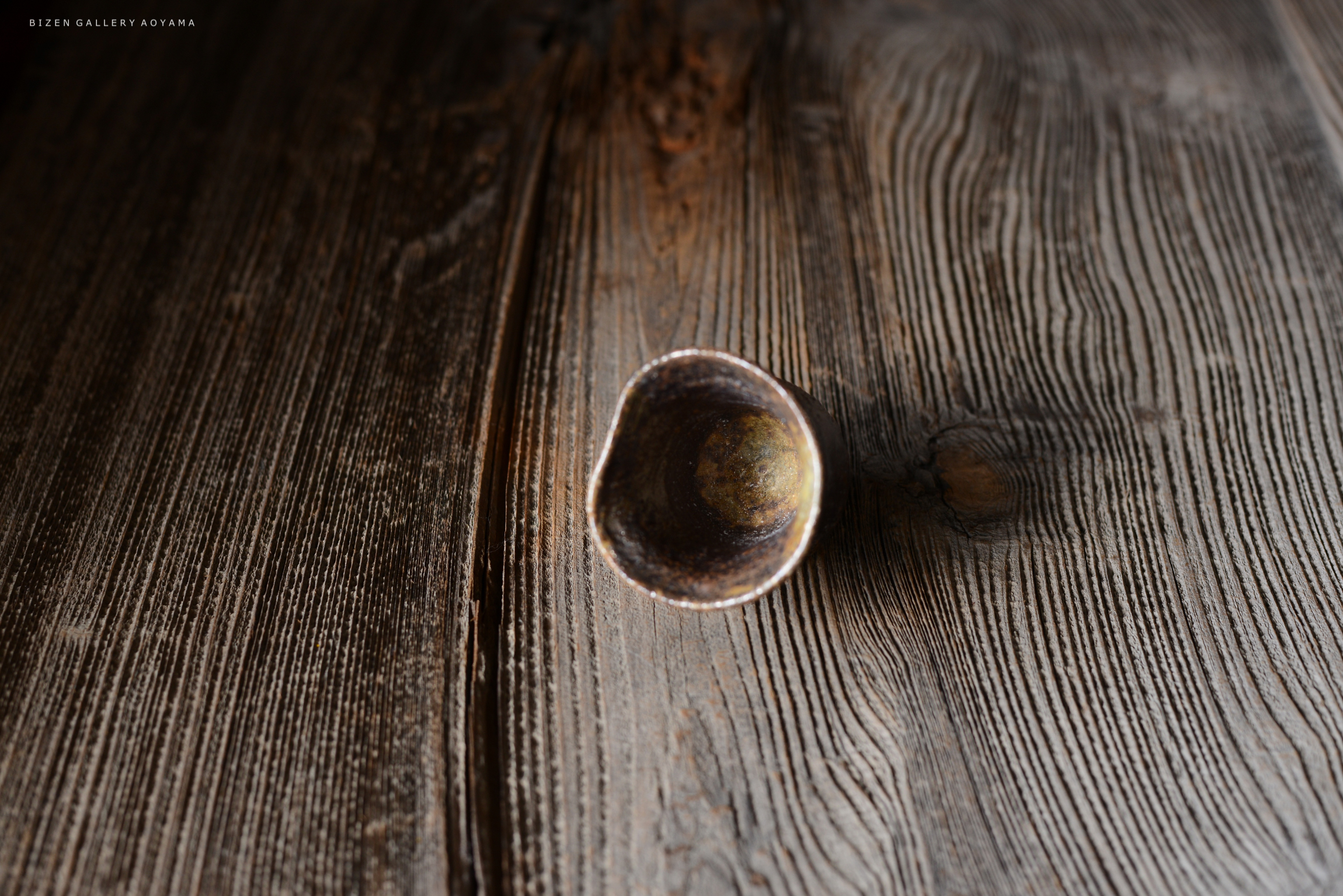 木製のテーブルの上に置かれた小さな陶器の器