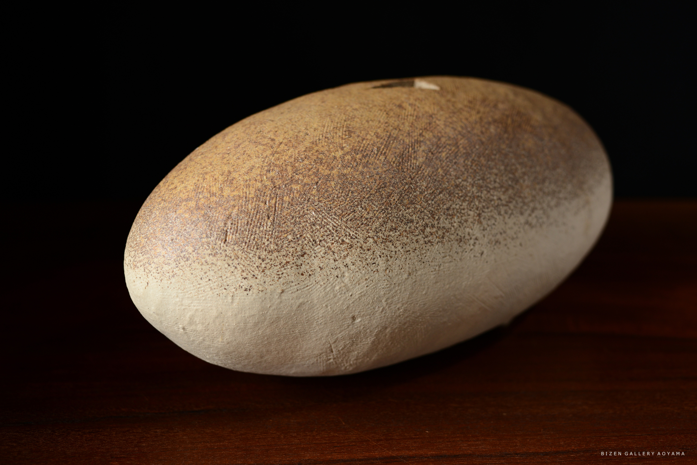 オブジェのような形状の陶器、上部は茶色のグラデーション、下部は白色の素焼き