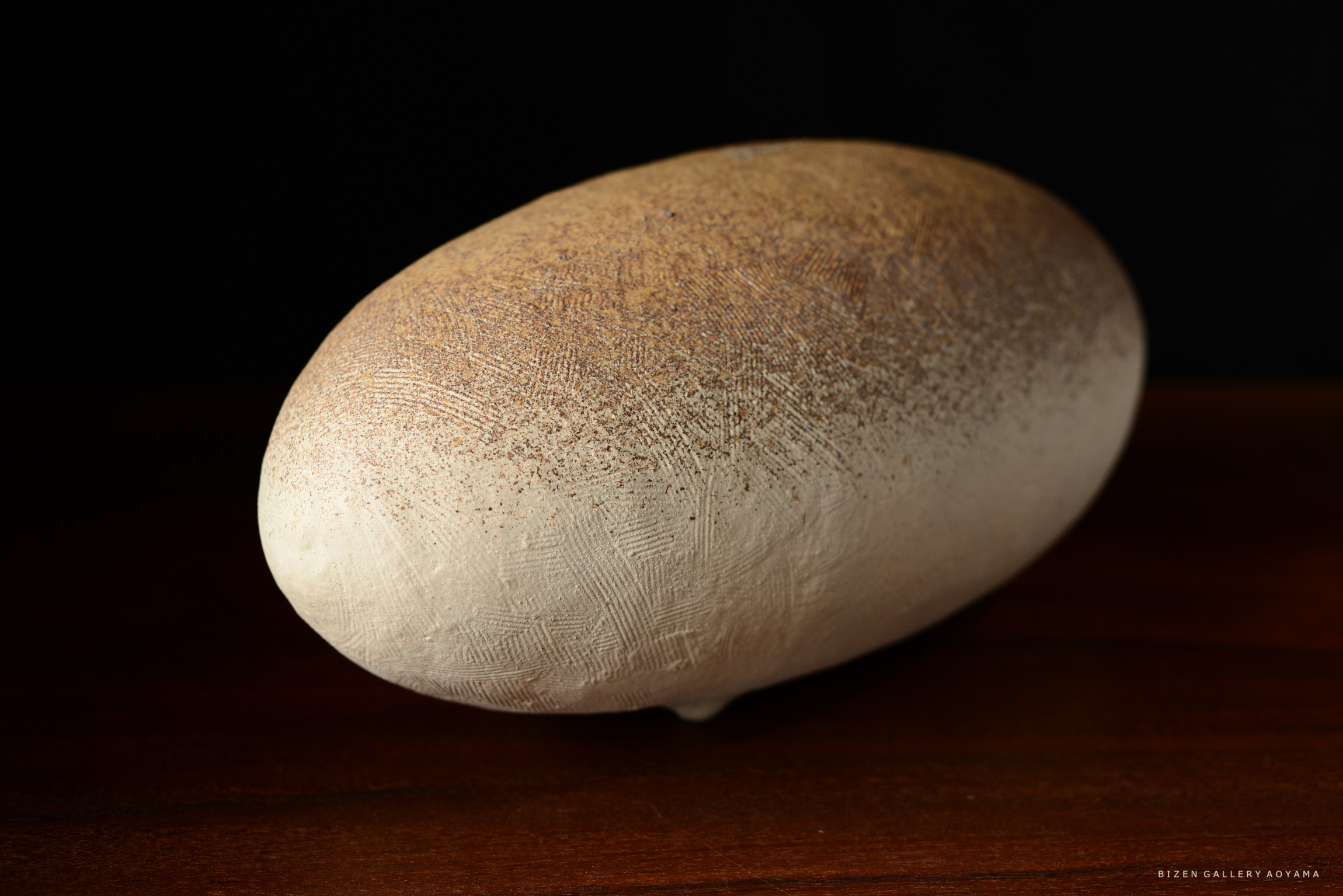 テーブルの上に置かれた形状の整った陶器のオブジェ。表面は滑らかで、自然な色合いが施されている。