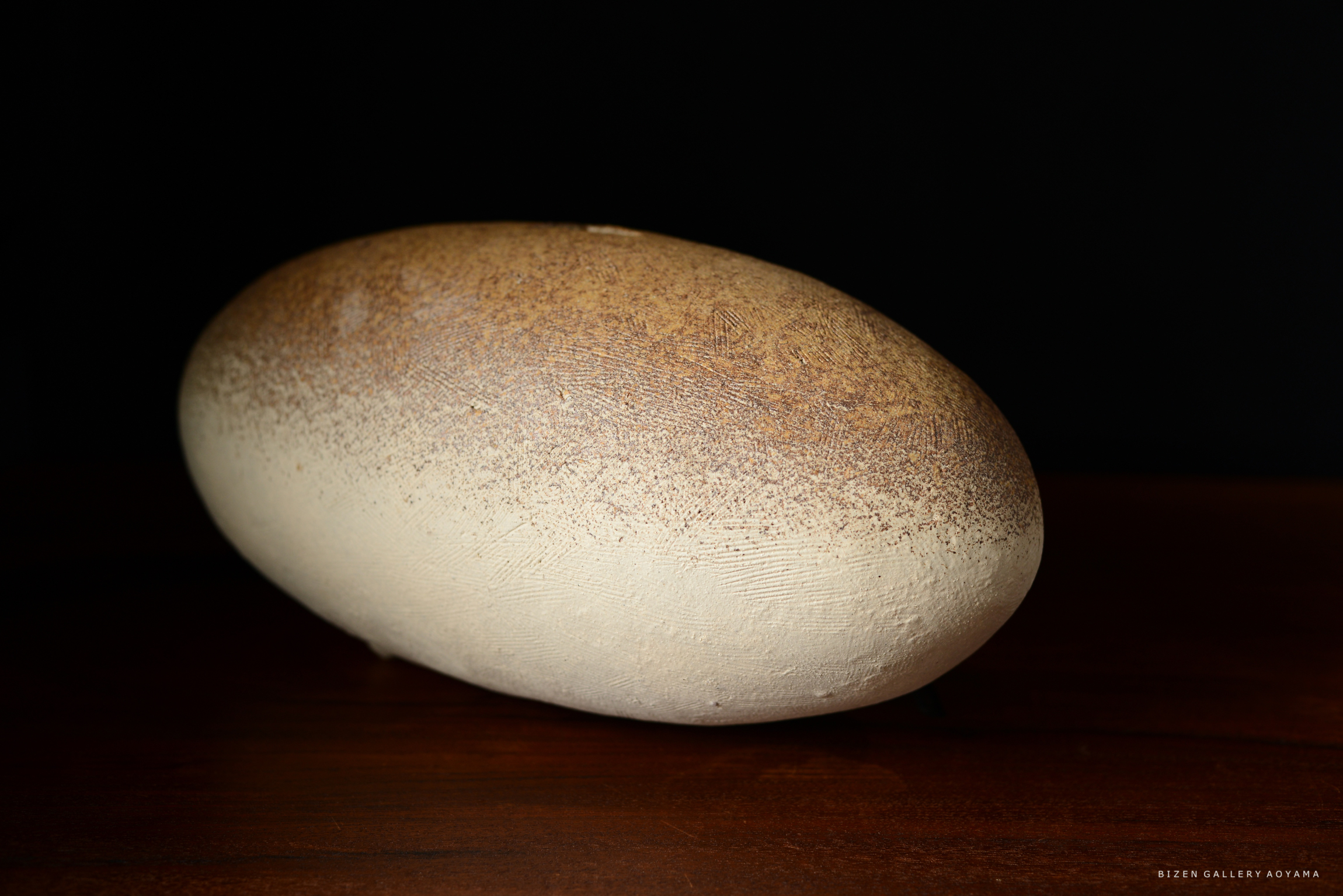 白と茶色のグラデーションが施された形状の陶器