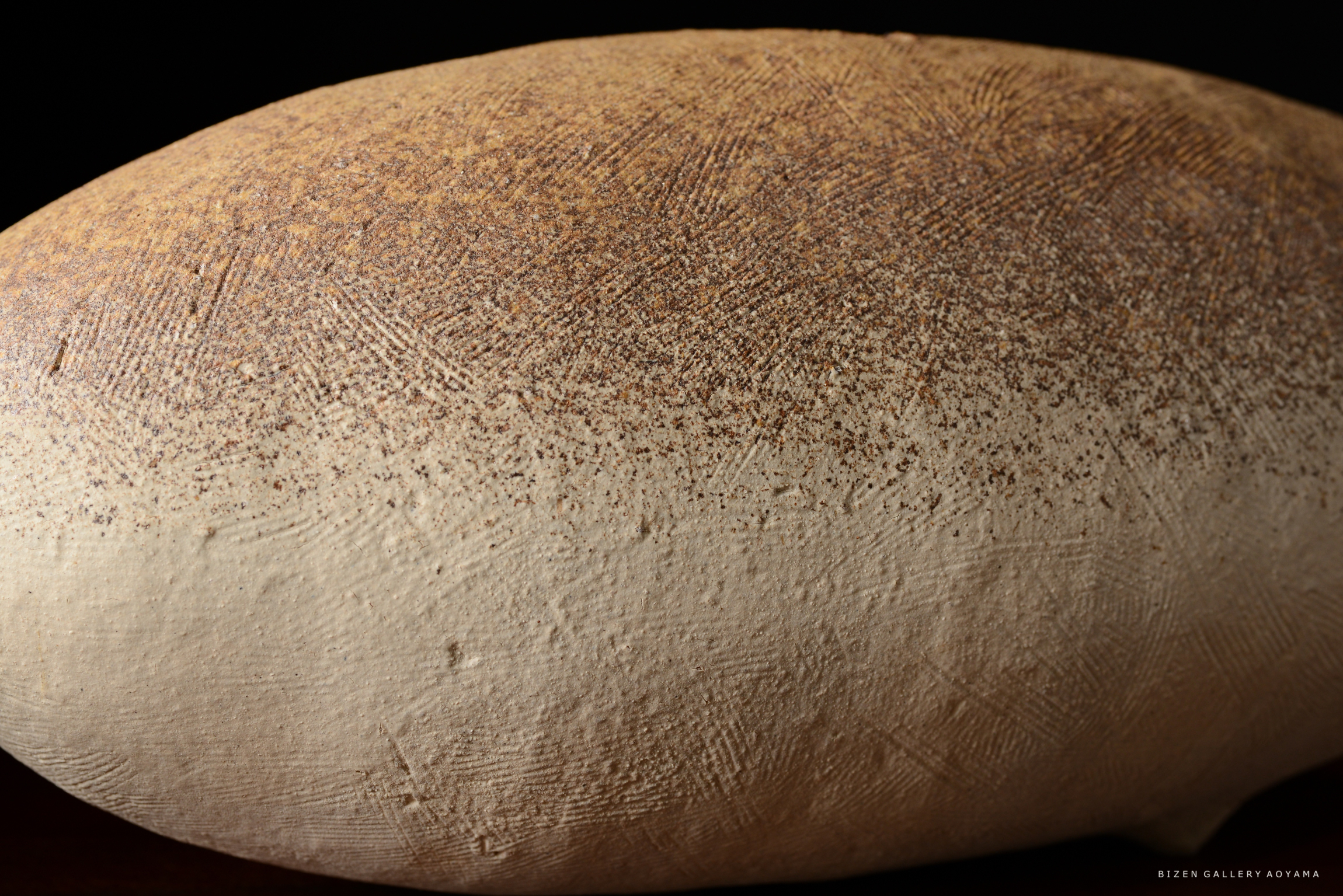 茶色い焼き物の表面、滑らかな質感と独特の模様が見られる。