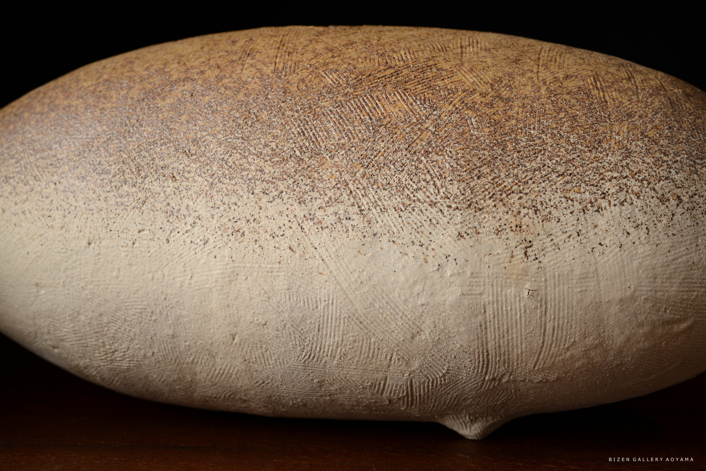 自然な色合いの陶器のアート作品。滑らかな表面と細かいテクスチャが特徴。