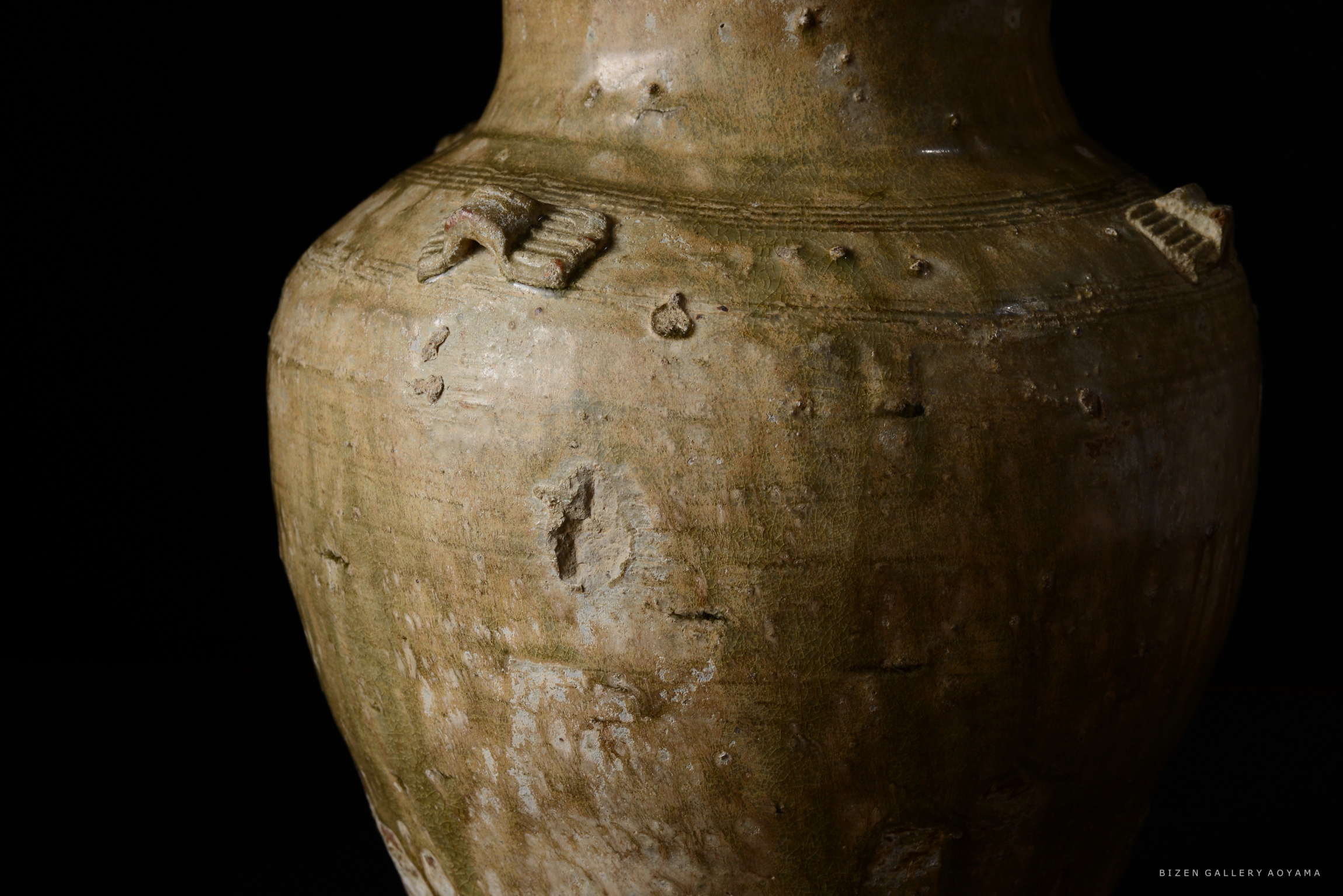 古い陶器の詳細なクローズアップ。土の質感と微細な傷が見える。背景は黒。