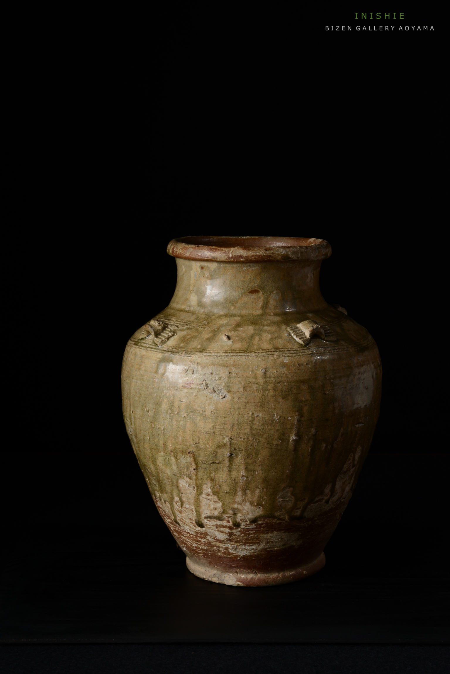 黒い背景の前に置かれた、独特な風合いを持つビゼン焼きの壺