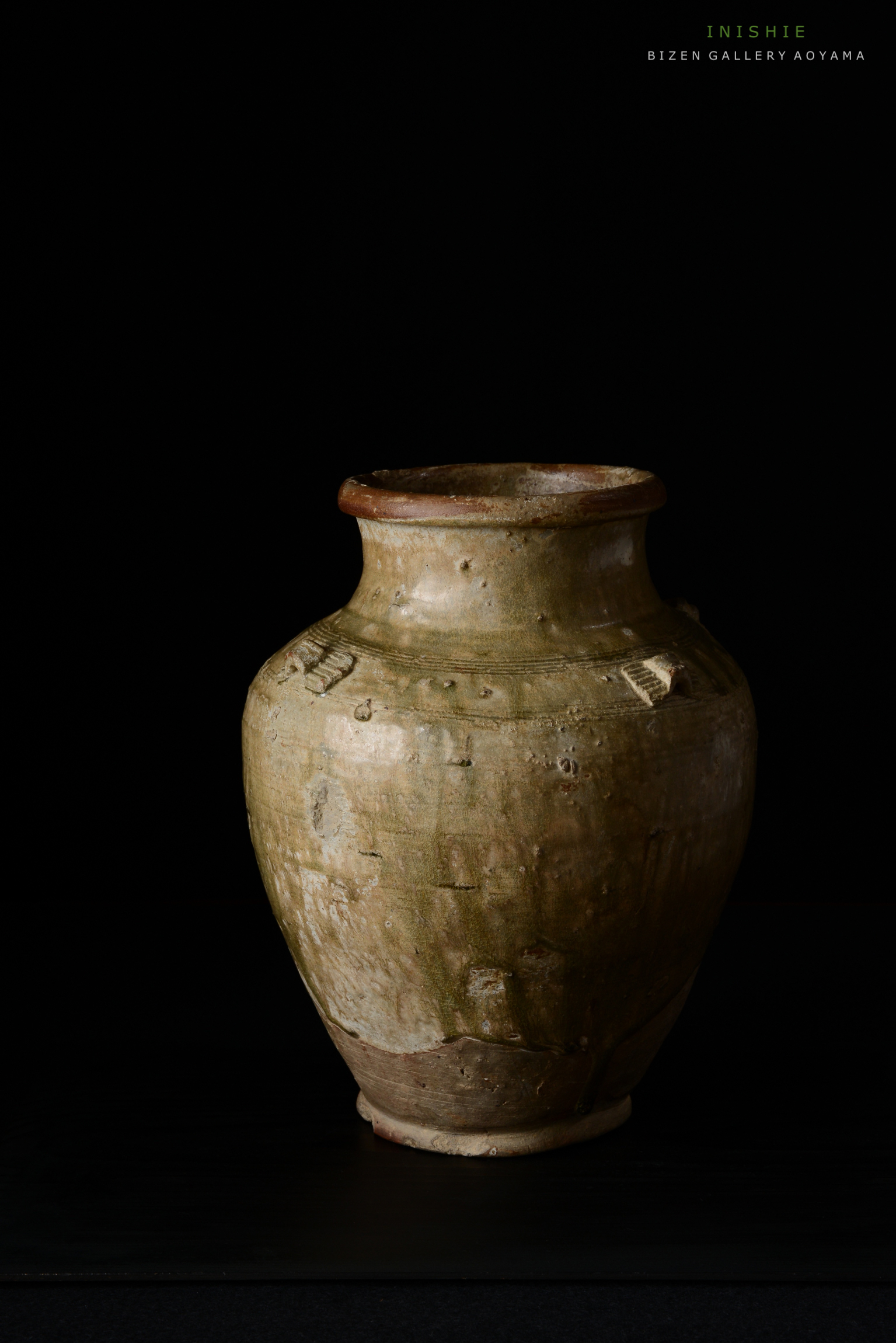 黒い背景に置かれたビゼン焼きの陶器。独特の形状と質感が特徴。