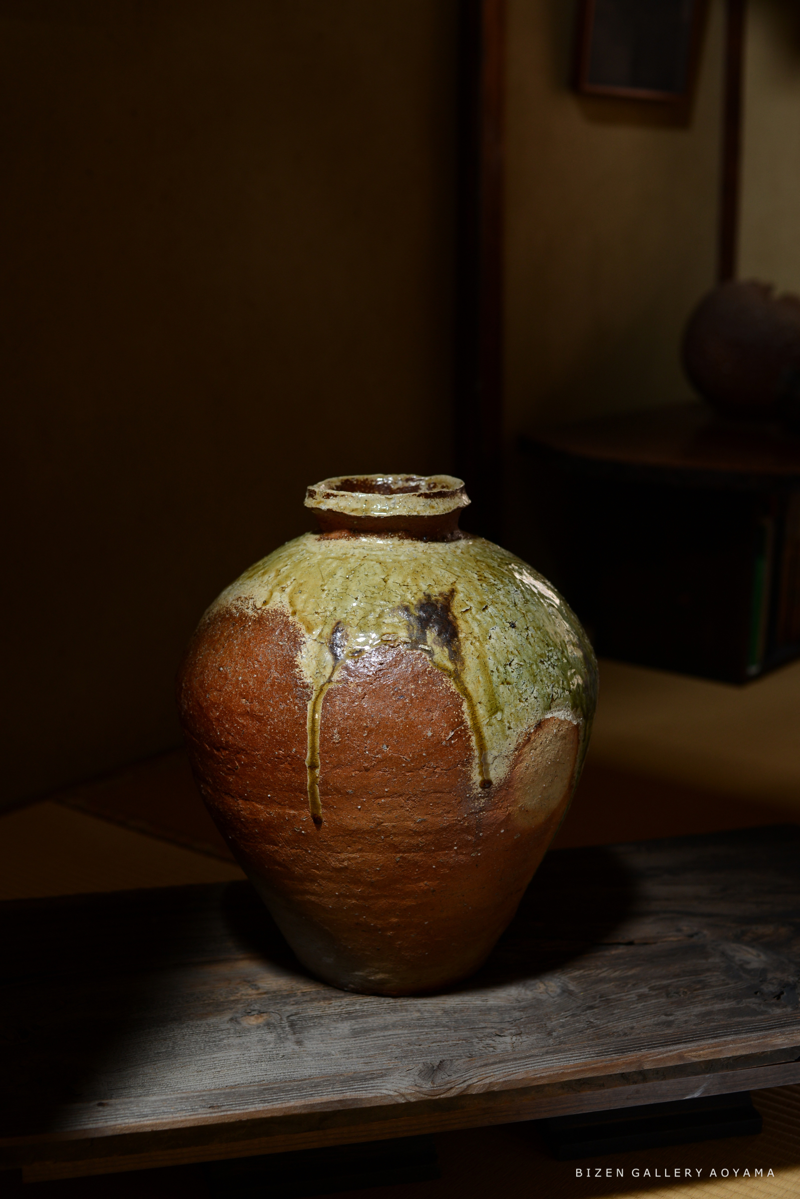 ビゼン焼きの陶器の壺、緑と茶色の釉薬の色合いが特徴的。