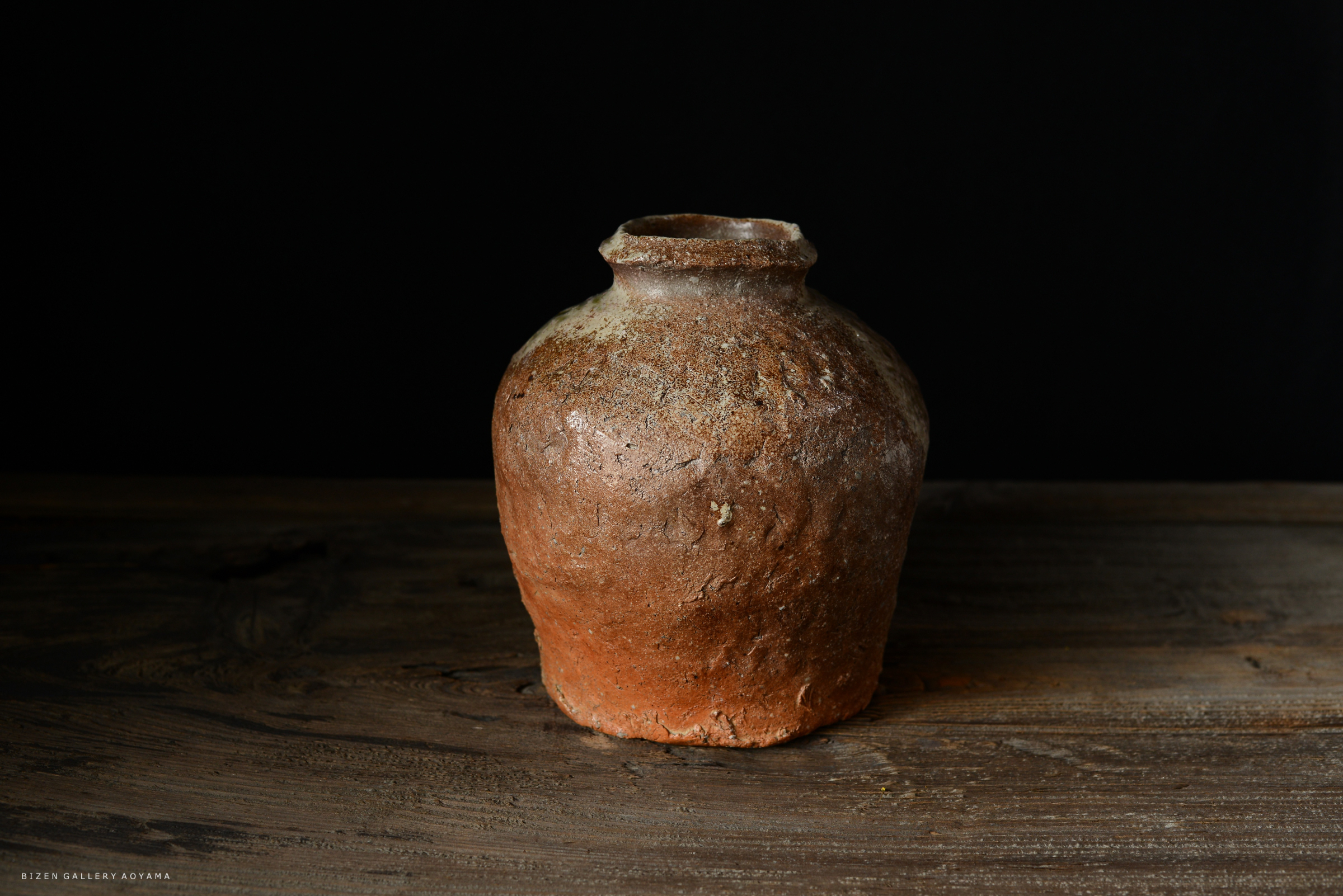 黒い背景の前に置かれた土製の壺