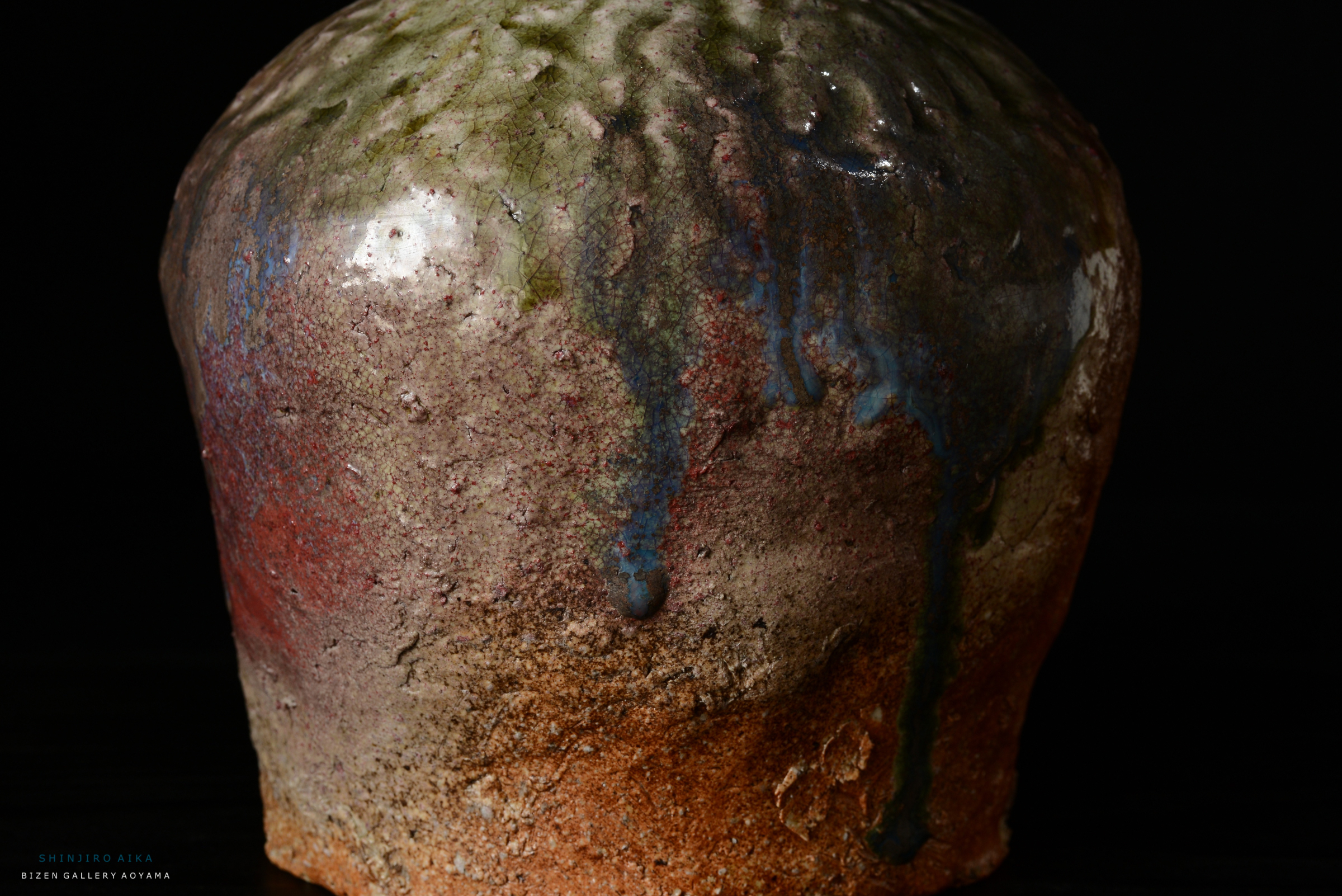 土で作られたアート作品の近接画像、色彩豊かな釉薬の流れが特徴。