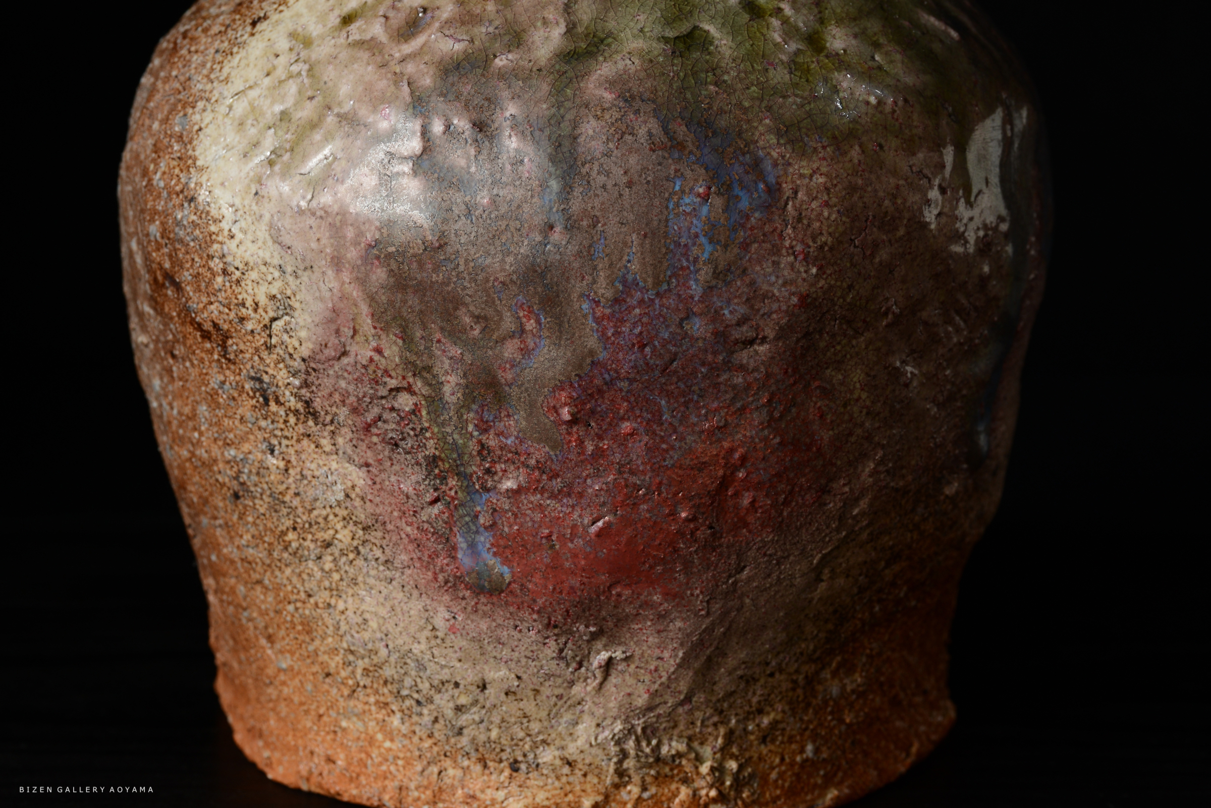 さまざまな色合いの釉薬が施された陶器の一部。表面は粗く、複雑な質感が見られる。