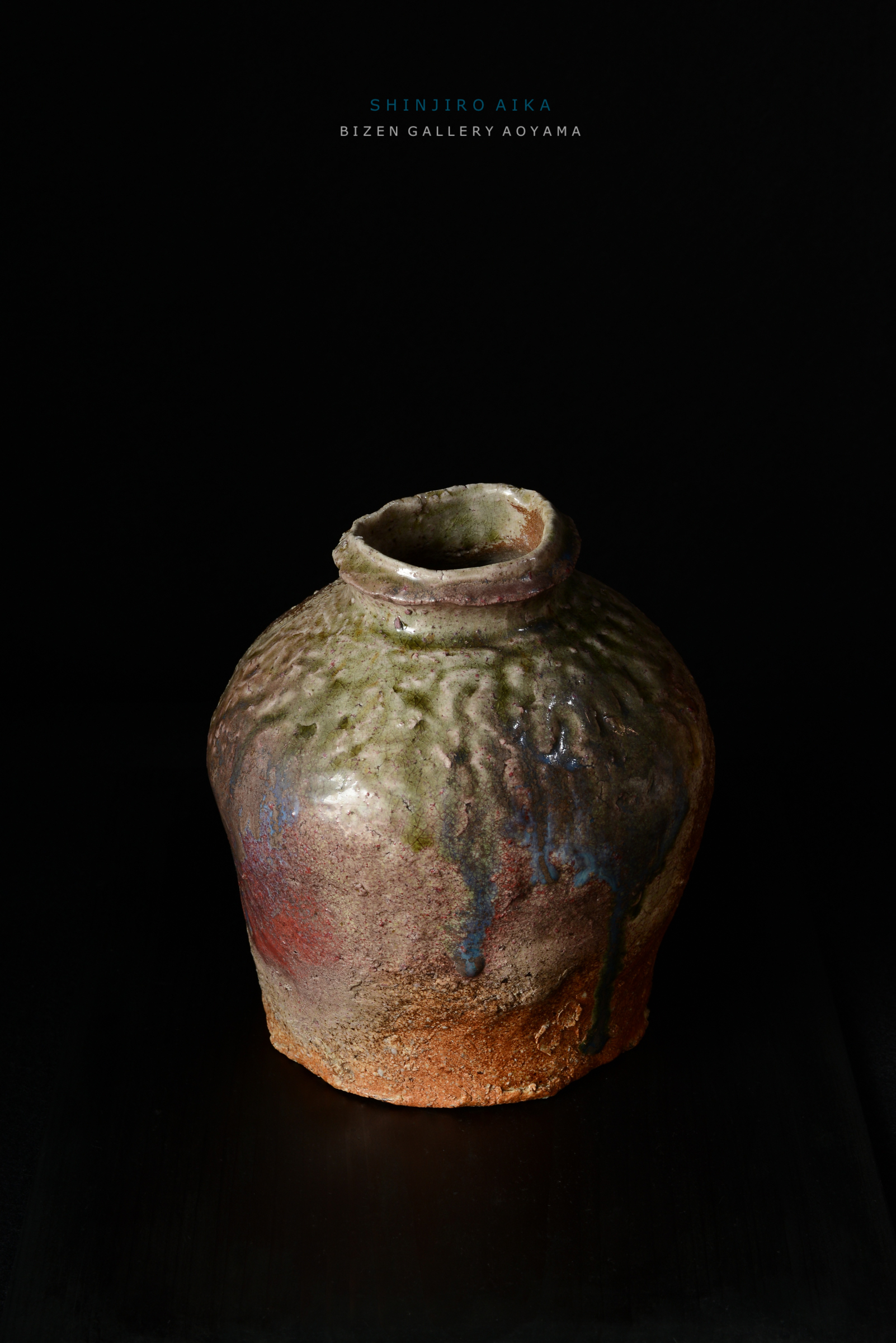 独特な形状のビゼン焼きの壺。さまざまな色合いと質感が見られる。背景は黒で、芸術的な雰囲気を醸し出している。