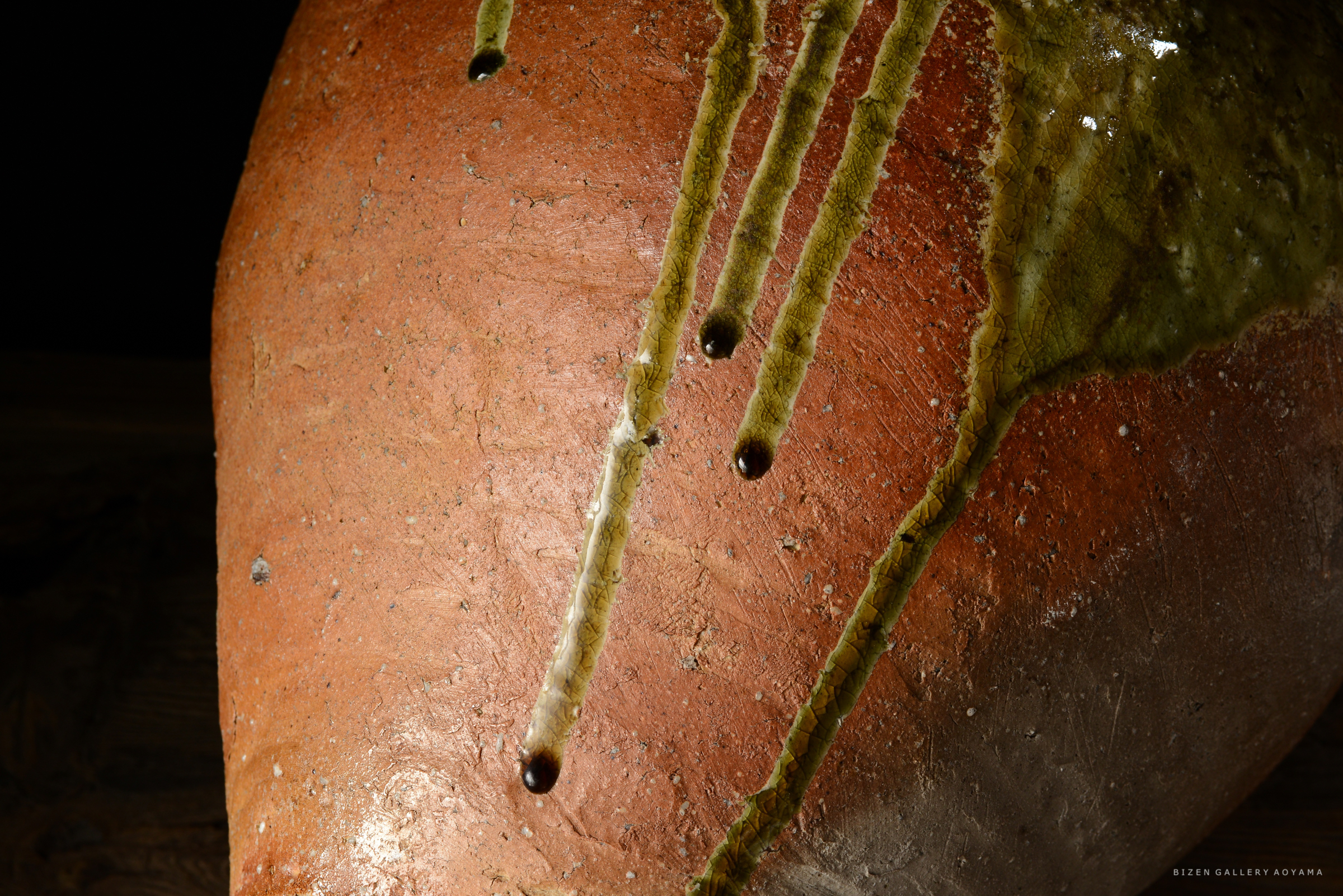 赤い素焼きの壺にかかった釉薬の滴