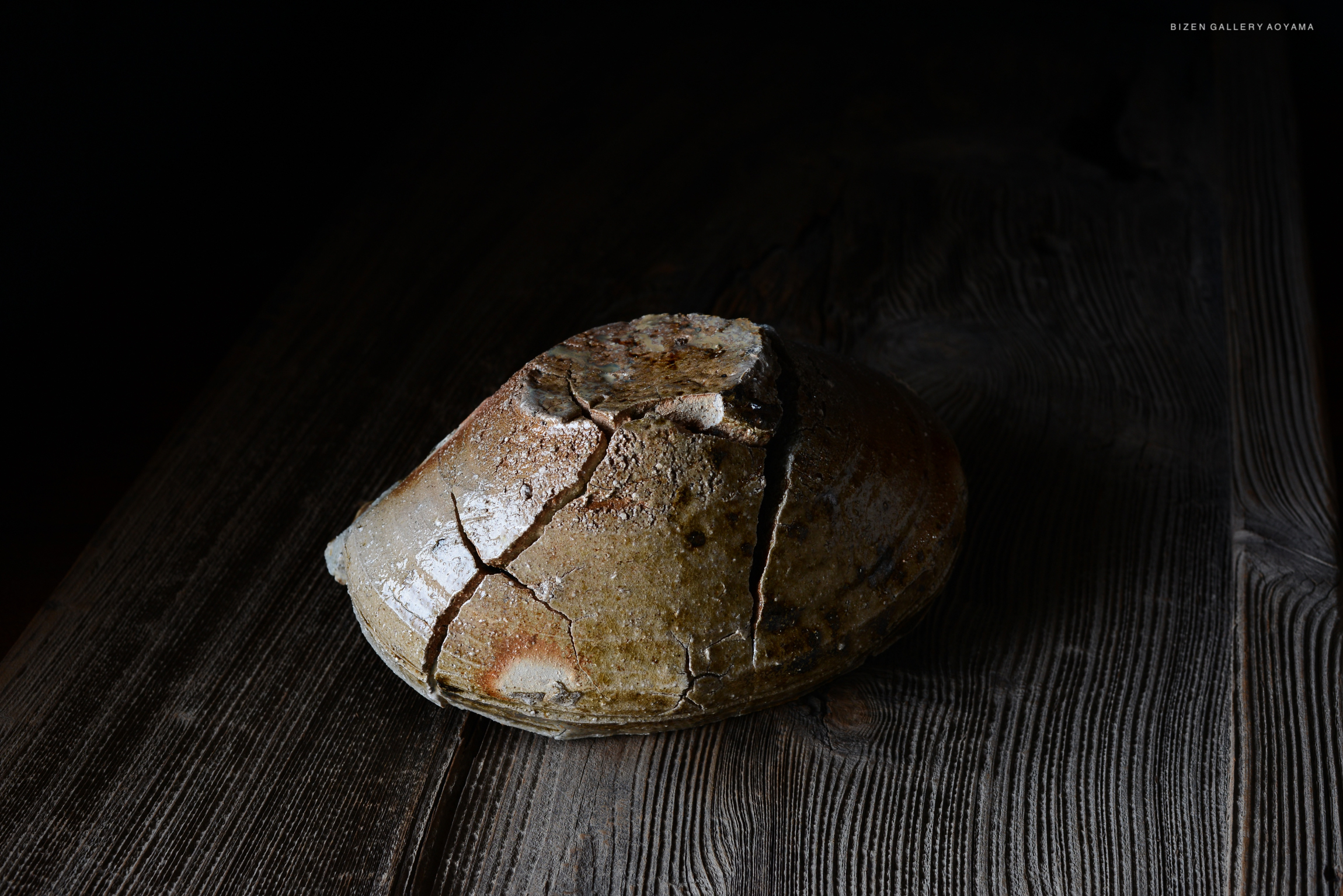 木のテーブルの上に置かれた、ひび割れた陶器の器の画像