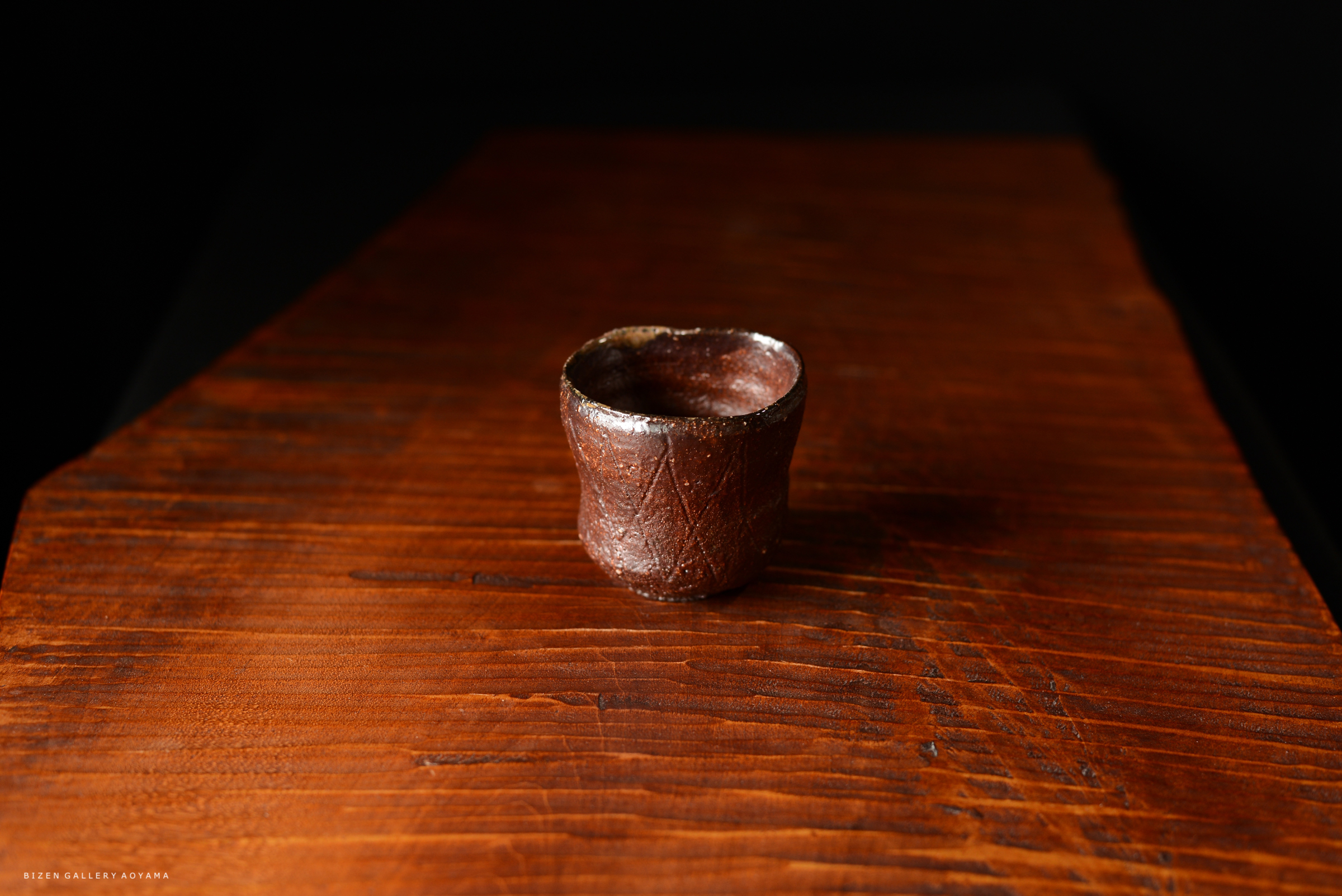 木製のテーブルの上に置かれた、小さな陶器のカップ