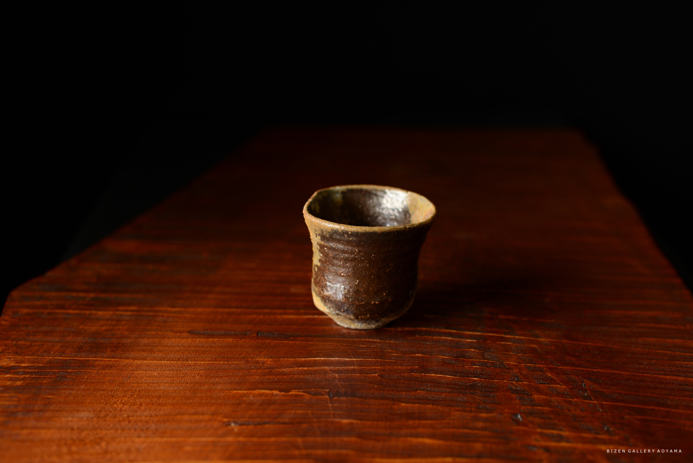 木製のテーブルの上に置かれた陶器の小さなカップ