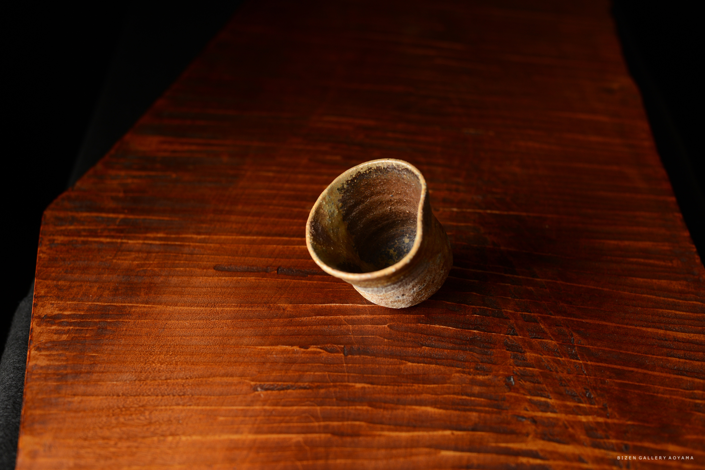 木製のテーブルの上に置かれた、独特な形状の陶器の器