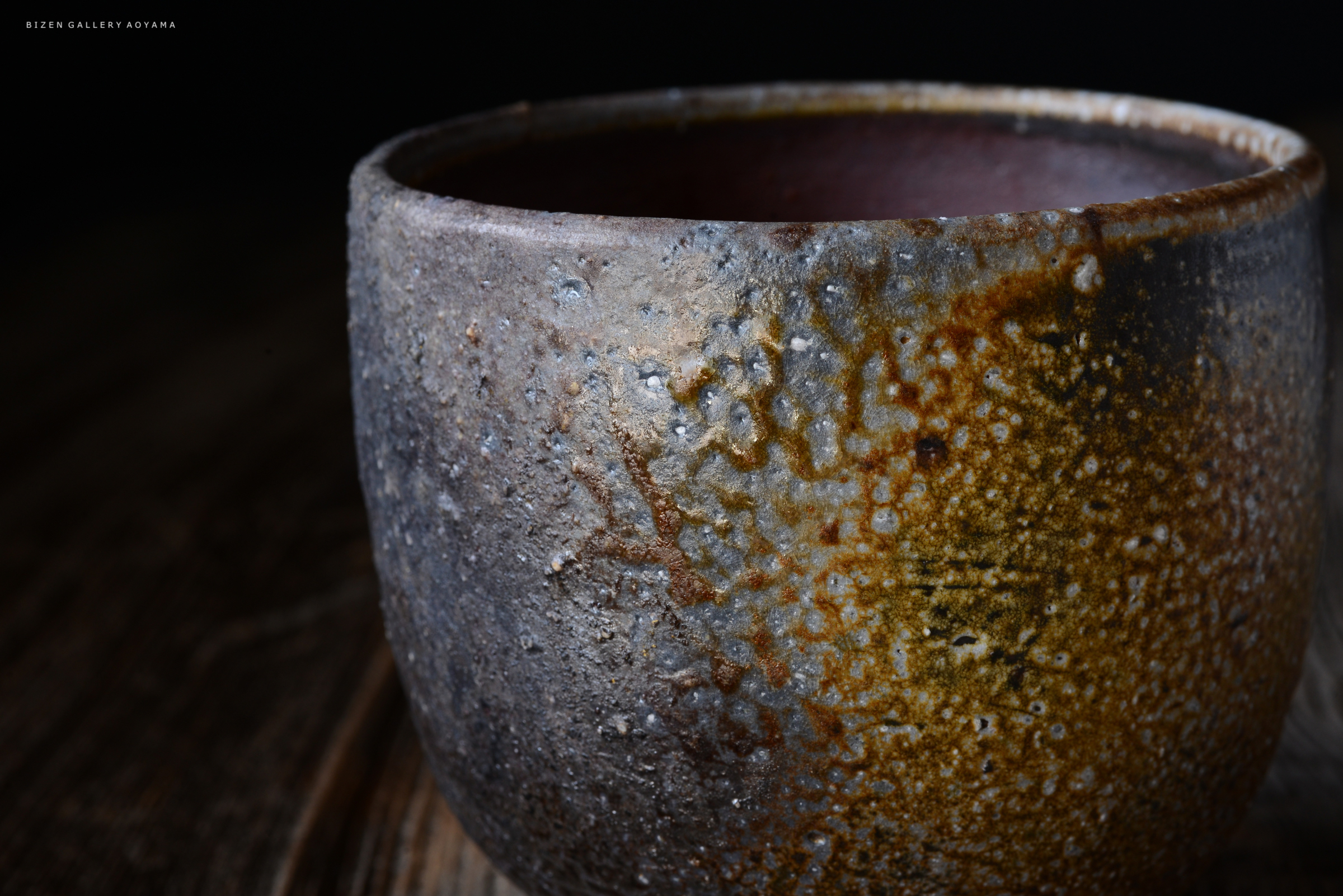 ざらざらした質感の茶碗。色合いは青灰色と茶色で、独特な釉薬の模様が見られる。